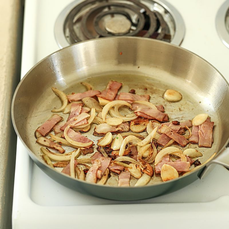 팬에 올리브오일을 두르고 버터를 녹인 후 마늘과 양파, 페퍼론치노를 넣어 볶다가 향이 올라오면 베이컨을 넣어 볶고 새우와 양송이버섯을 넣어 볶아주세요.