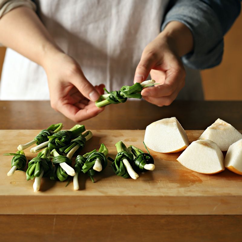 쪽파는 다듬어 씻어 감아서 묶고 배는 껍질 채 깨끗이 씻고 씨를 뺀 후 큼직하게 썰어주세요. 양파와 대파는 깨끗이 씻어 4등분하고 마늘과 생강은 손질해서 편으로 썬 후 청양고추와 홍고추는 2등분하고 씨를 털어 준비해주세요.