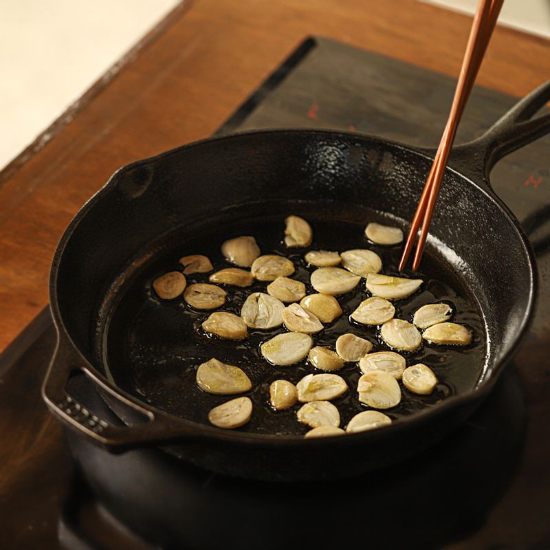 달군 팬에 올리브오일을 두르고 마늘을 넣어 볶아주세요. 마늘이 노릇해지면 페퍼론치노와 고사리를 넣고 볶다가 면수를 넣어 주세요.