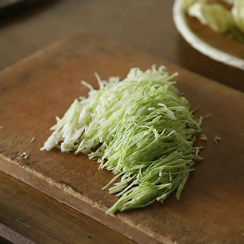 깨끗이 씻은 양배추는 두꺼운 심지 부분을 자르고 채를 썰어주세요. 당근, 잎채소도 비슷한 길이로 채를 썰어 주세요.