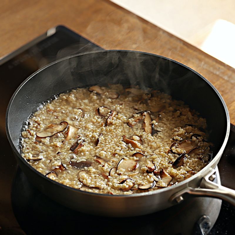 채수 절반을 부어 뚜껑을 닫고 중약불에서 10분간 끓여 주세요. 채수가 반 정도 졸아들면 남은 채수를 넣고 주걱으로 저어가며 현미를 익혀주세요.