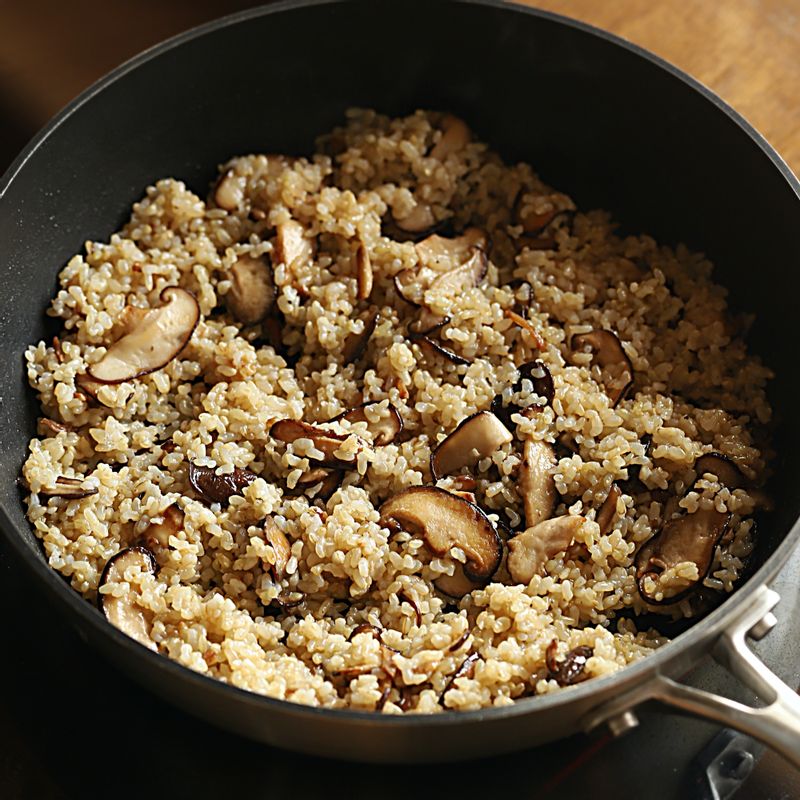 볶은 버섯에 현미밥을 넣고 고루 섞어주세요. 화이트와인을 넣어 알콜이 날아가도록 볶아주세요.