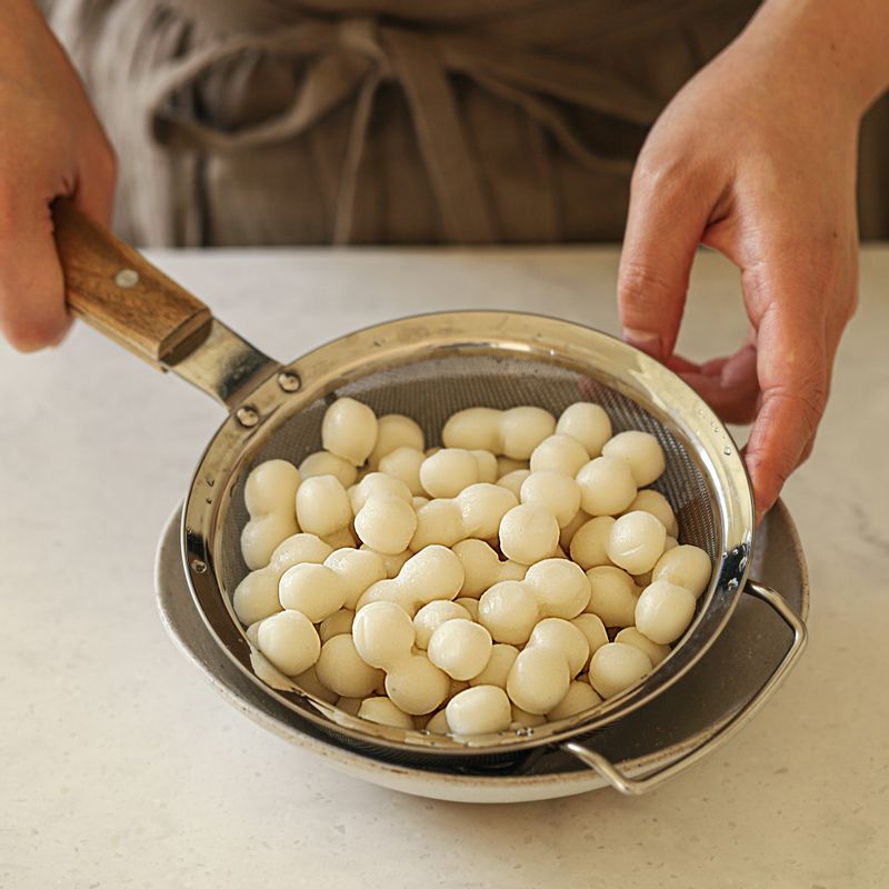 조랭이떡은 찬물에 담갔다가 체에 밭쳐 물기를 빼주세요. 대파는 어슷하게 썰어주세요.