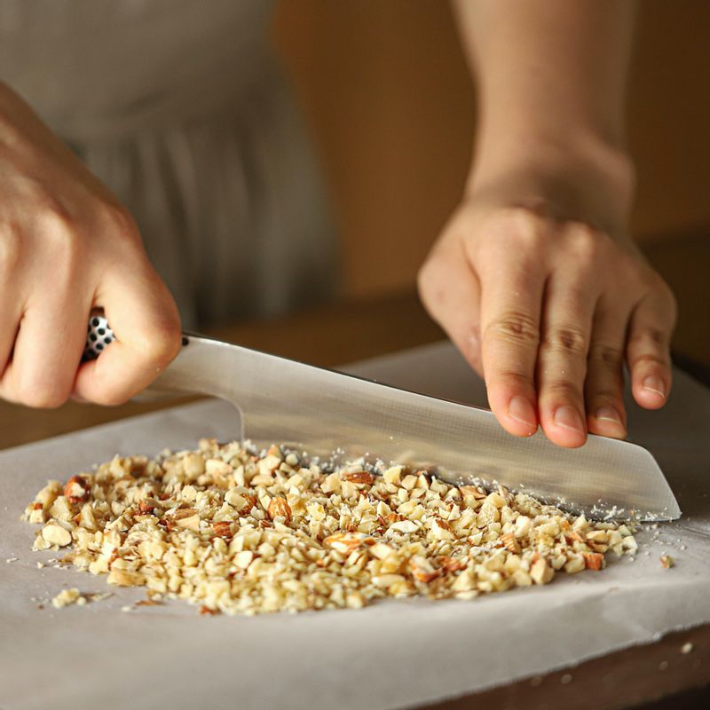 도마에 종이를 깔고 견과류를 올려 잘게 다진 후 볼에 크림치즈와 함께 섞어주세요