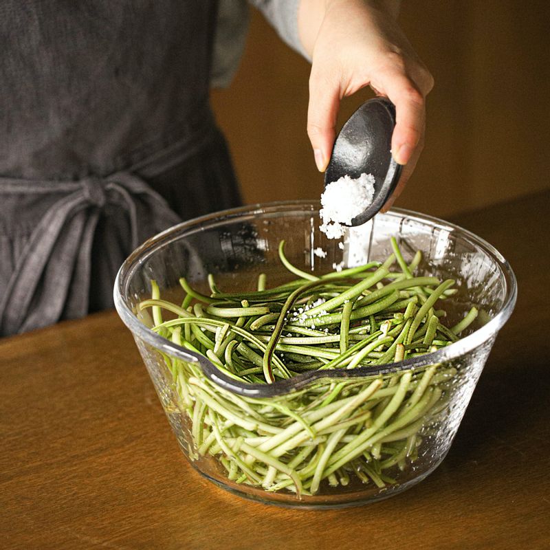 껍질 벗긴 고구마순은 깨끗이 씻고 굵은소금을 뿌린 후 중간에 위 아래로 뒤집어가며 30분정도 절이고 씻어 물기를 빼주세요.
(tip 고구마순을 구부렸을 때 부러지지 않고 휘어질 정도로 절여주세요.)