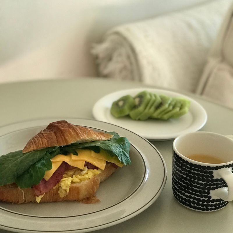 크로와상샌드위치🥪 , 우유를 살짝 넣어 만든 스크램블과 알맞게 구운 베이컨, 치즈 한장, 아주 많이 사랑하는 루꼴라를 넣어 주면 든든한 굿모닝 아침입니다. , 여기에 사과즙과 키위 한조각이면 🧡 , 오늘도 온기 가득한 날 되세요🌿 ,   #크로와상샌드위치 #샌드위치 #홈브런치 #온더테이블 #크로와상